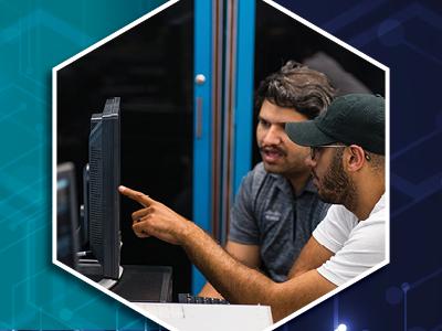 Two males in front of a computer monitor